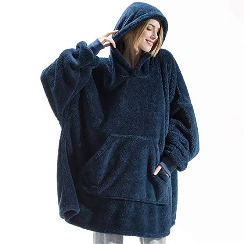 The oversized fleece hoodie in navy, hood up, one hand in the large front pocket