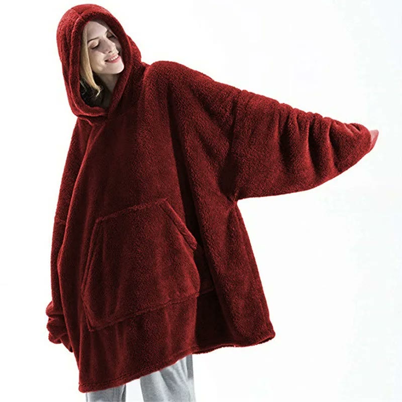 The same hoodie in red with an arm outstretched, showing how wide the body and sleeves cut